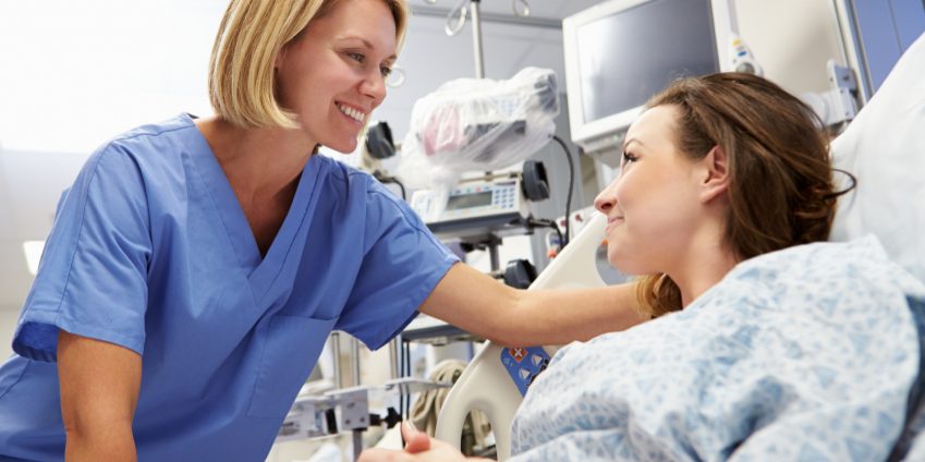 Young Female Patient Talking To Nurse In Emergency Room Young Female Patient Talking To Nurse In Emergency Room