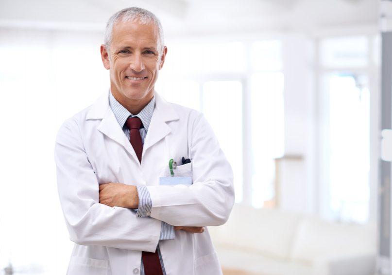 Portrait of a mature doctor standing with his arms folded